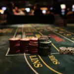 Stacked casino chips and two dice on a dark green craps table, arranged for a pass line odds strategy